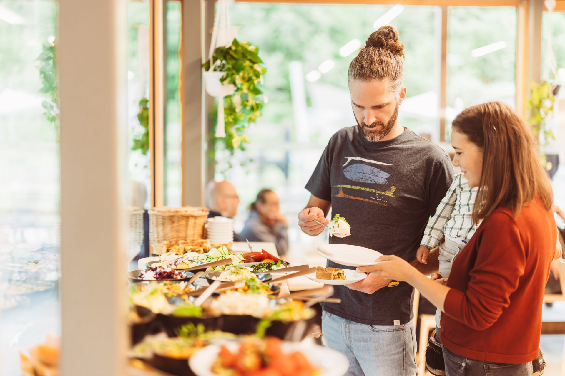 Junge Familie steht am Buffet